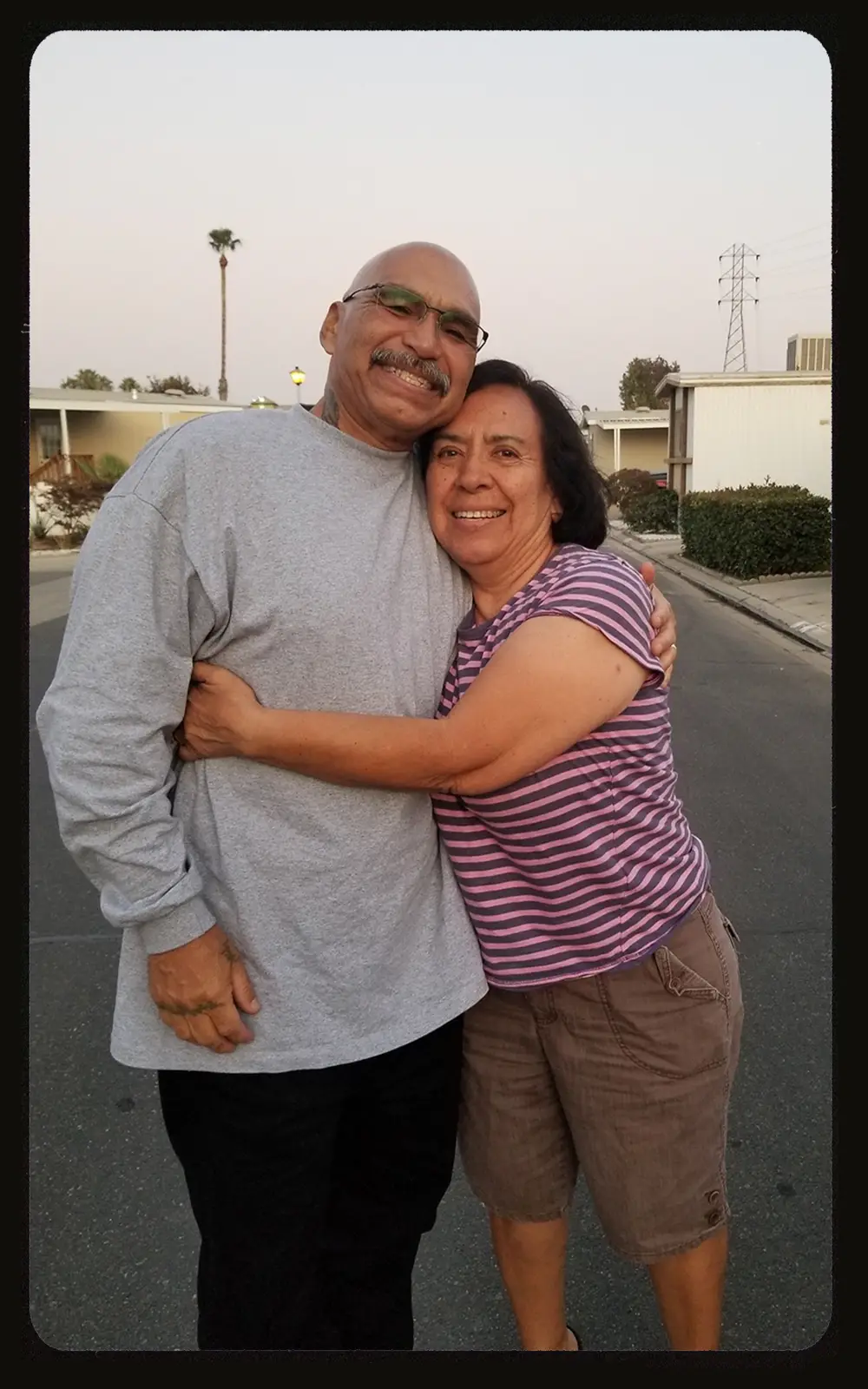 A man and a woman hugging, taking a photo
