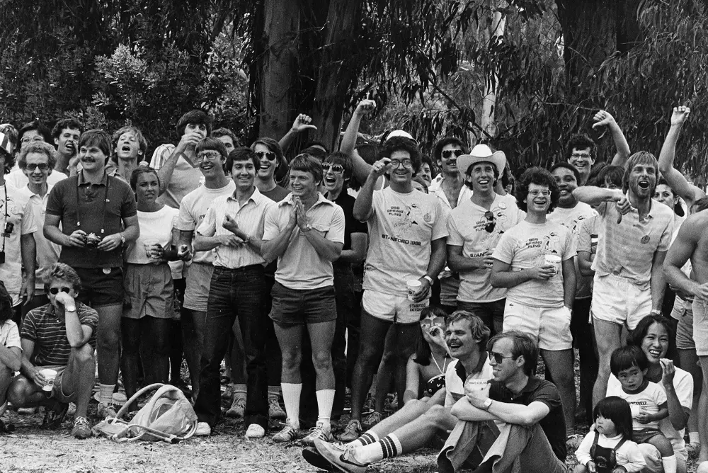 Black and white photo of a group of Stanford University people cheering