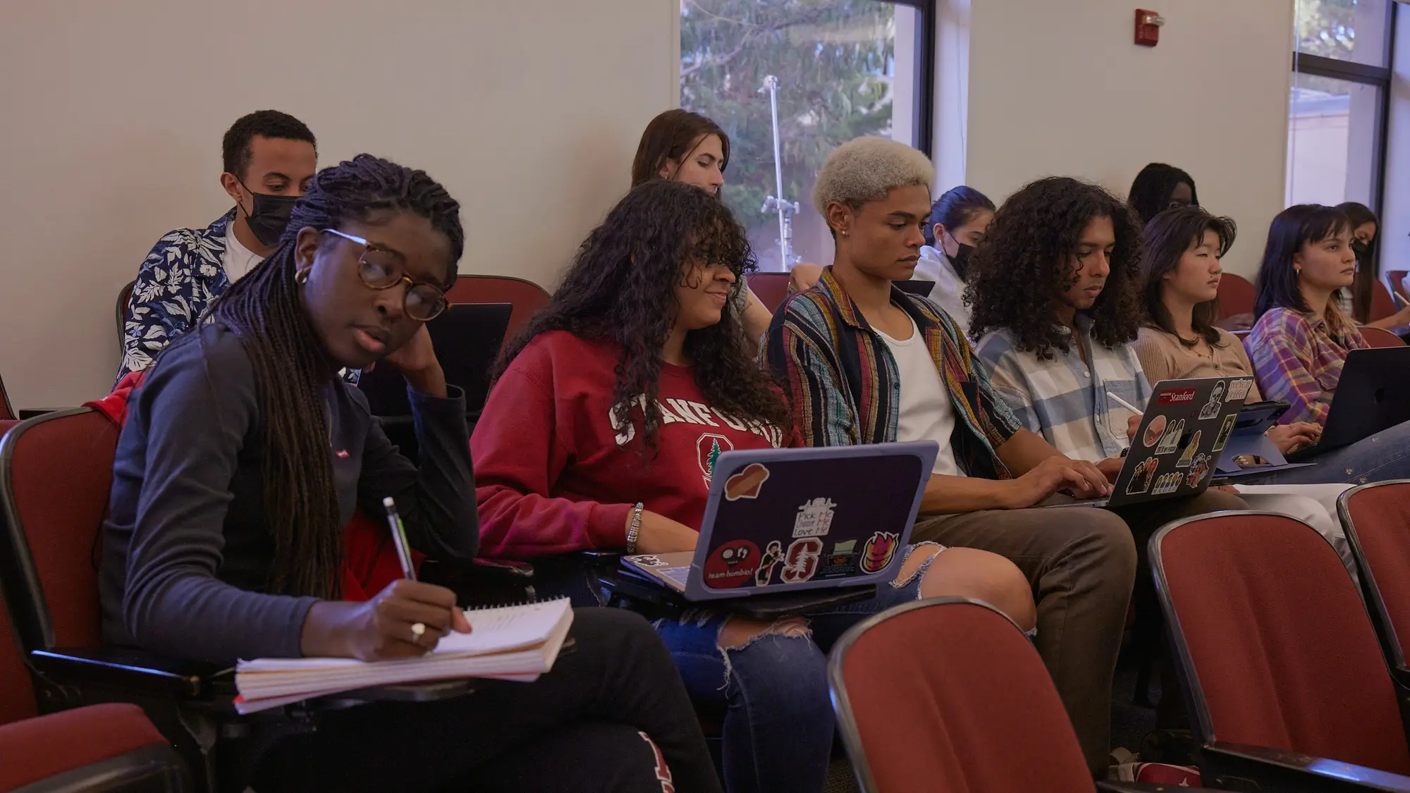 Students seated in class take notes