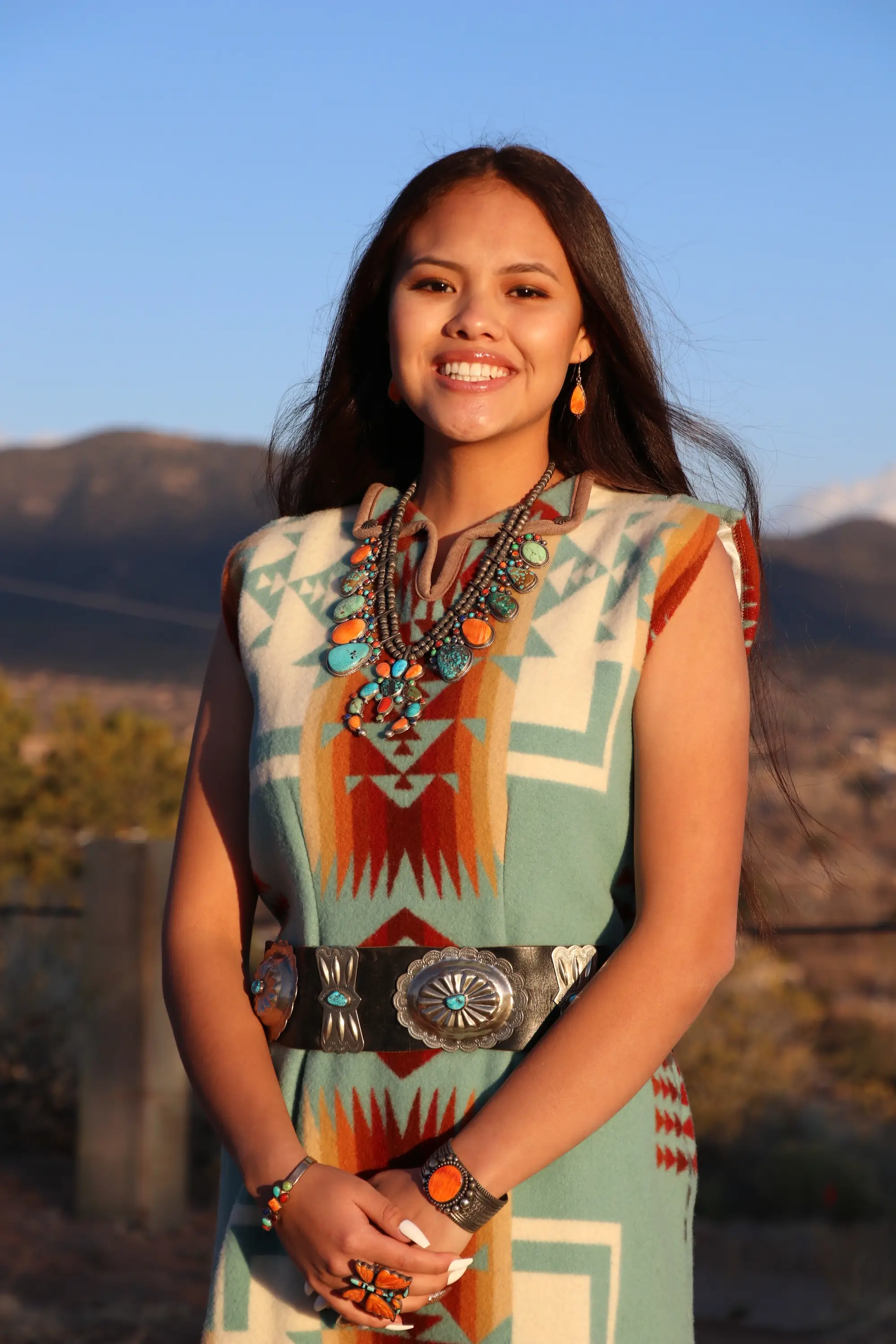 Larissa smiles wearing native jewelry