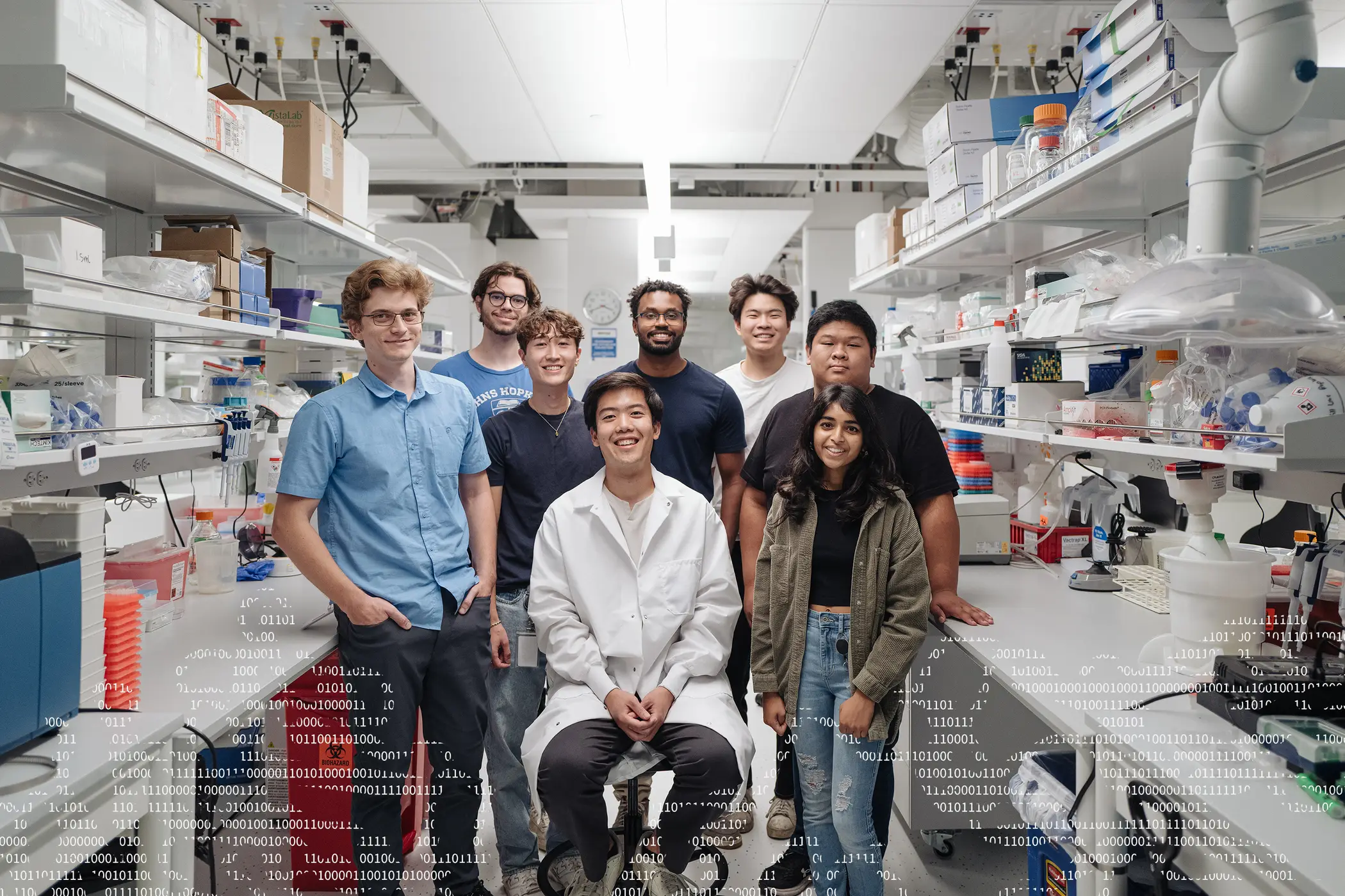 A group of researchers in a lab looking into the camera