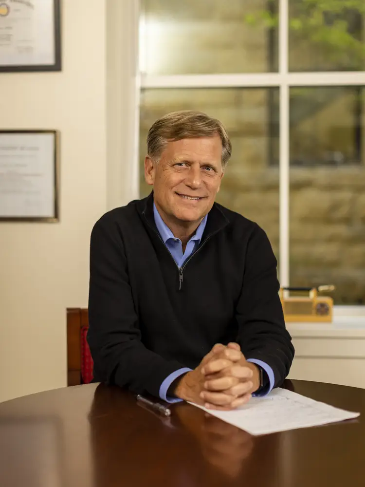 Political Science Professor Michael McFaul sits at a table smiling