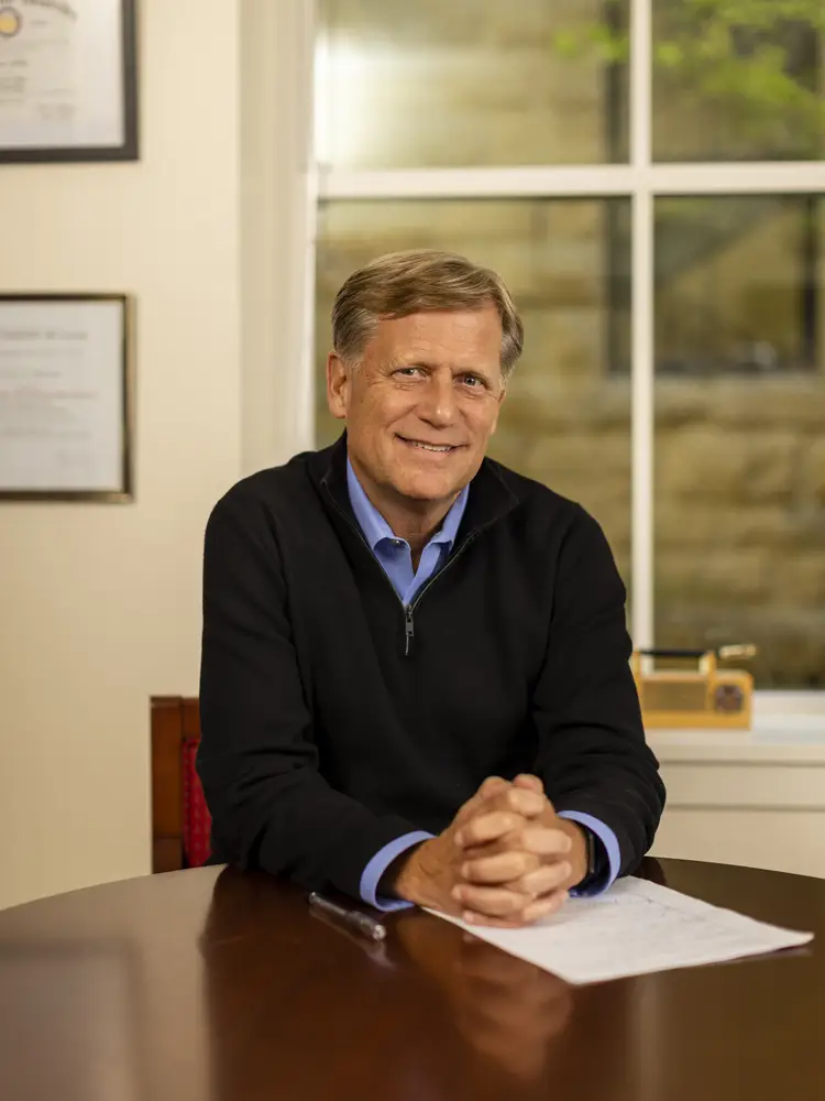 Political Science Professor Michael McFaul sits at a table smiling