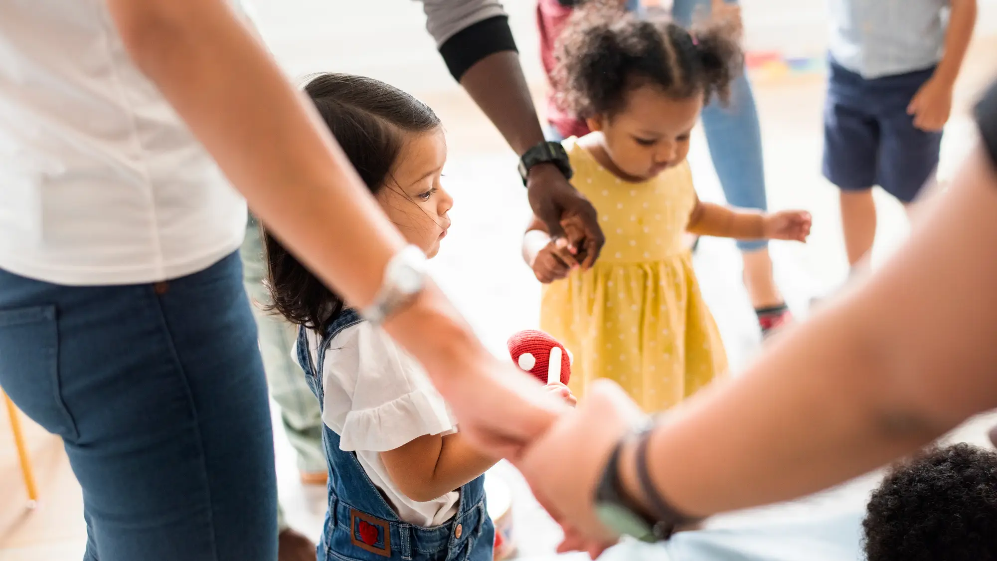 A circle of hands are joined with two small children shown