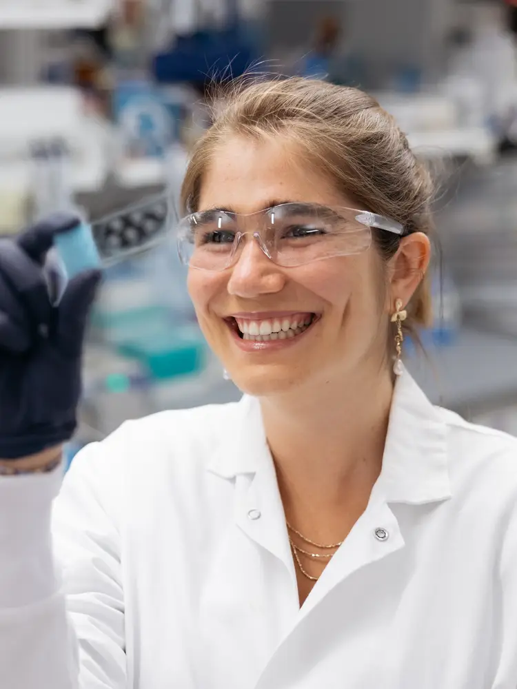Hoffmann closeup, smiling at the camera, holding a piece of equipment