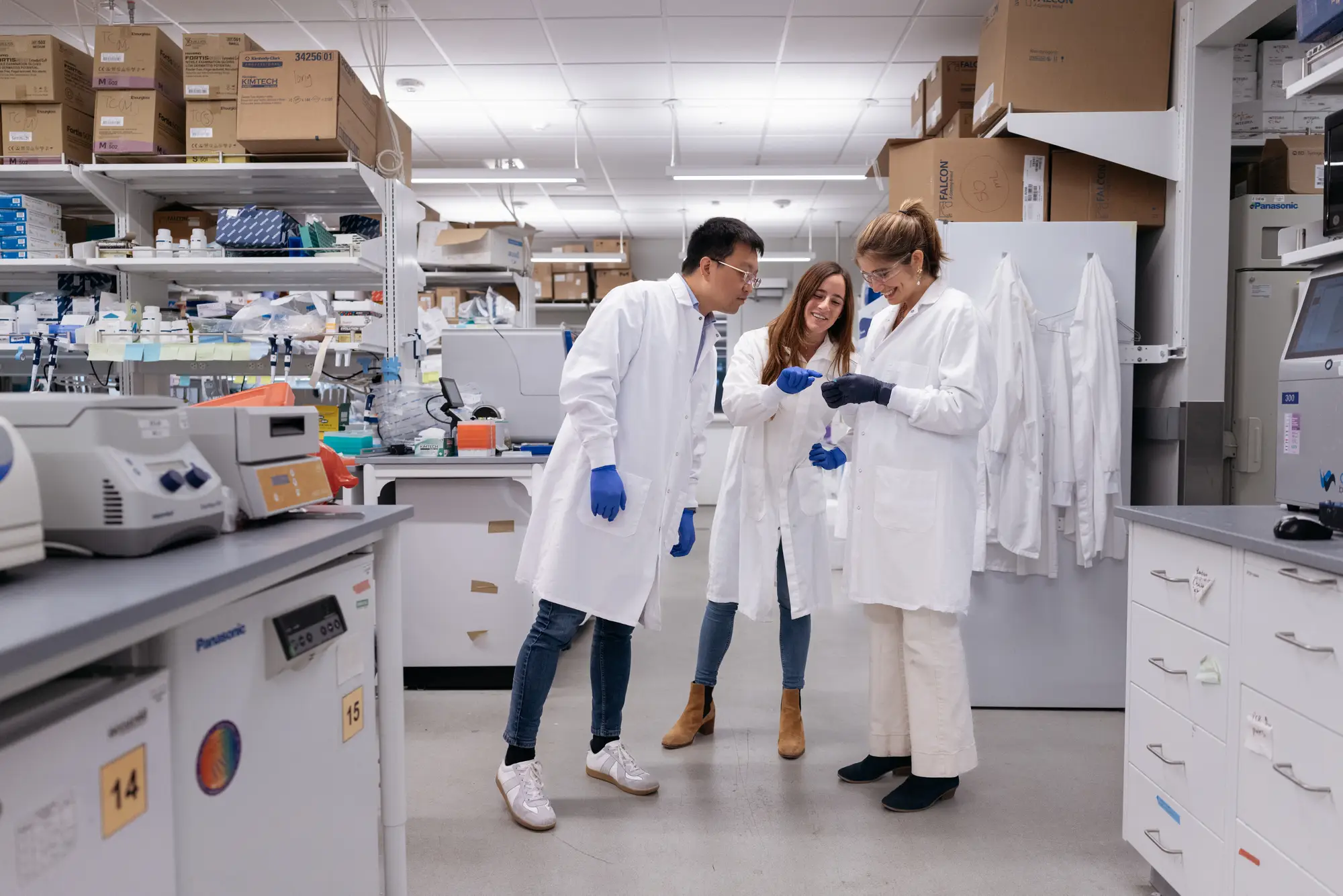 Hoffmann standing with two other researchers in her lab looking at something