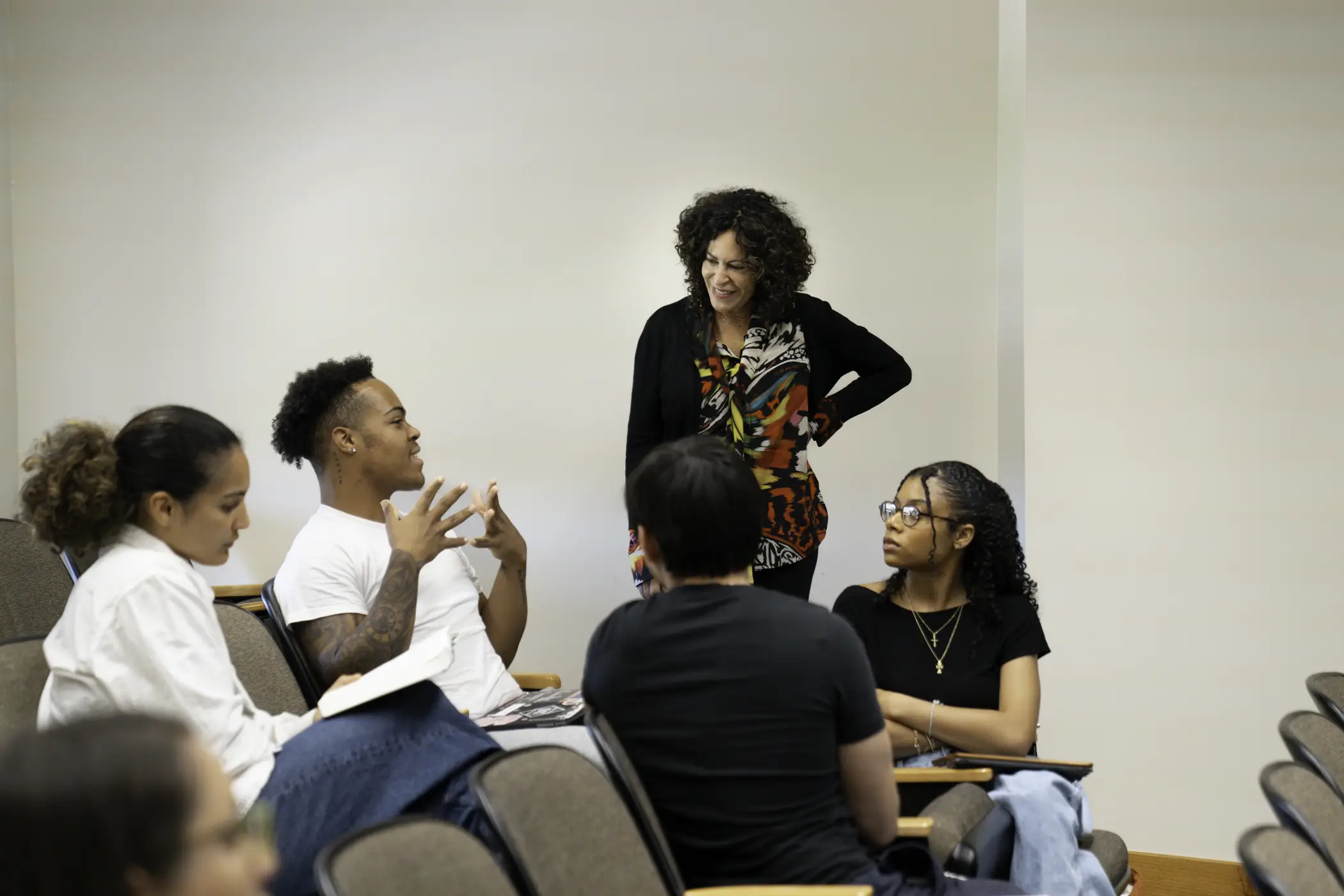 Michele Elam stands in a classroom talking with a group of students who are seated. 