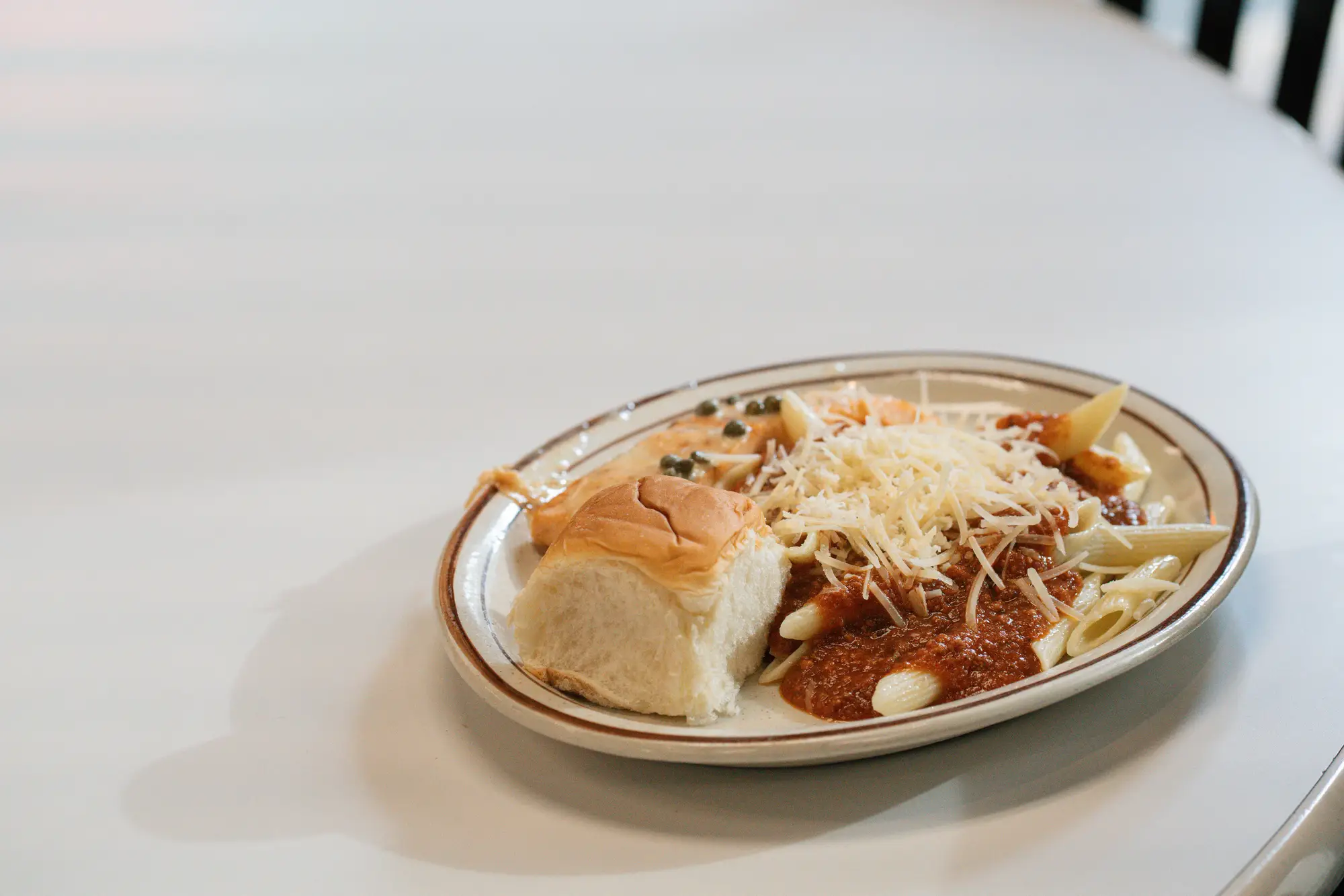 A lunch plate filled with pasta and bread.