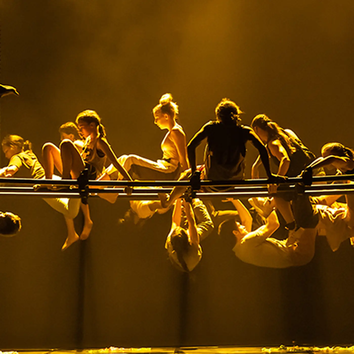 Dancers hang from a structure