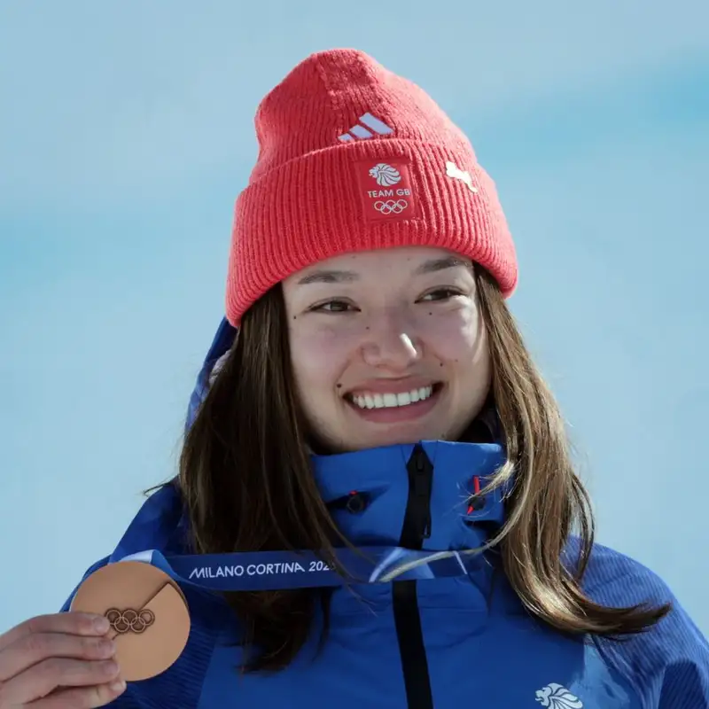 Zoe Atkin smiles while holding up her bronze medal.