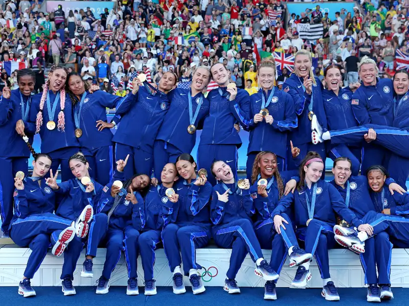 United States Women's National soccer team celebrating winning a gold medal at the Olympics.