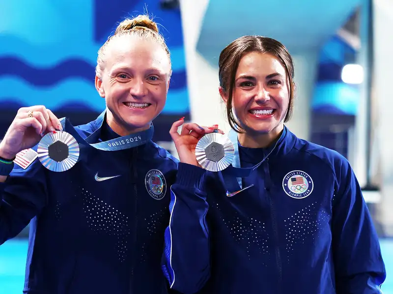 Kassidy Cook and her teammate smile as they hold up their silver medals at the Paris 2024 Olympics.