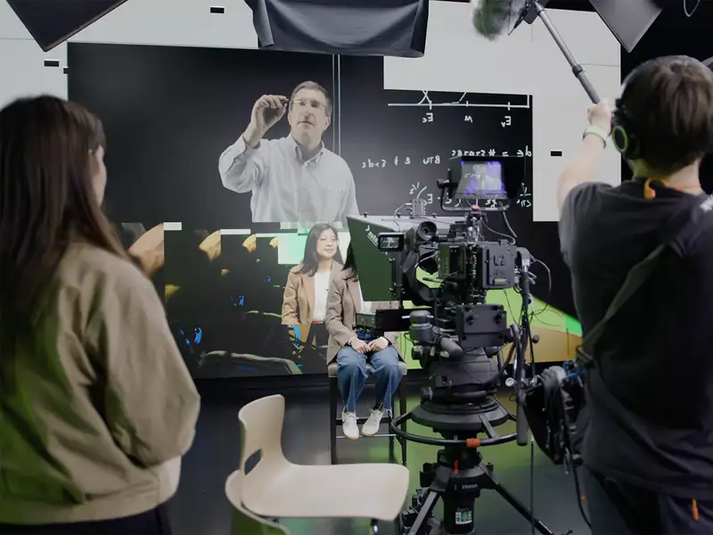Film crew producing video content on a green screen set with professional cameras and lighting equipment.