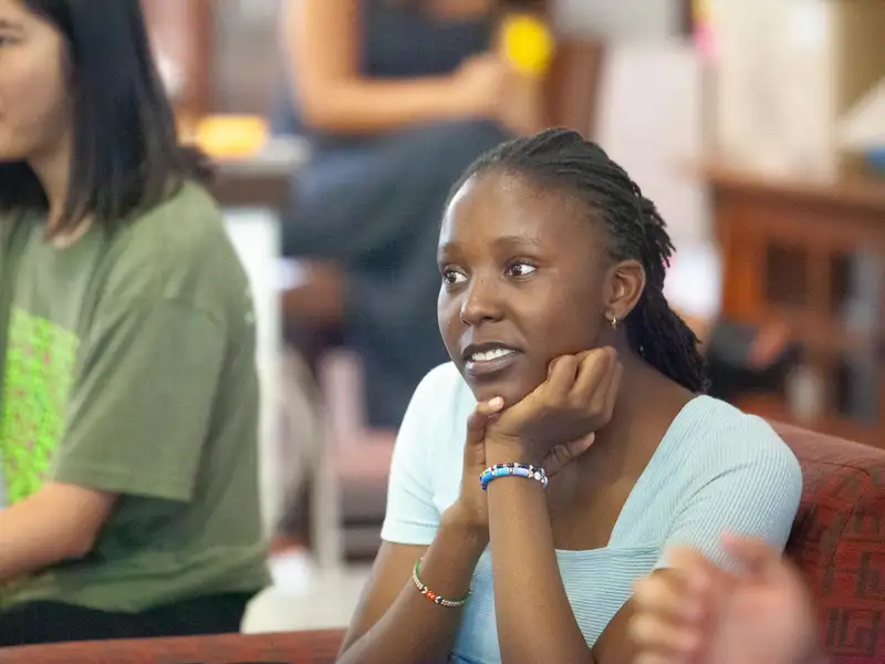 Two students sitting next to each other, focused on an activity in a classroom setting.