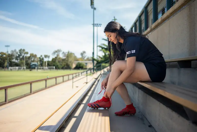 Student tying cleat shoes
