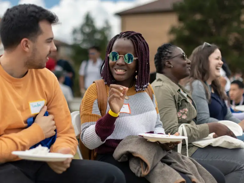 Students with nametags having a conversation outside at an event