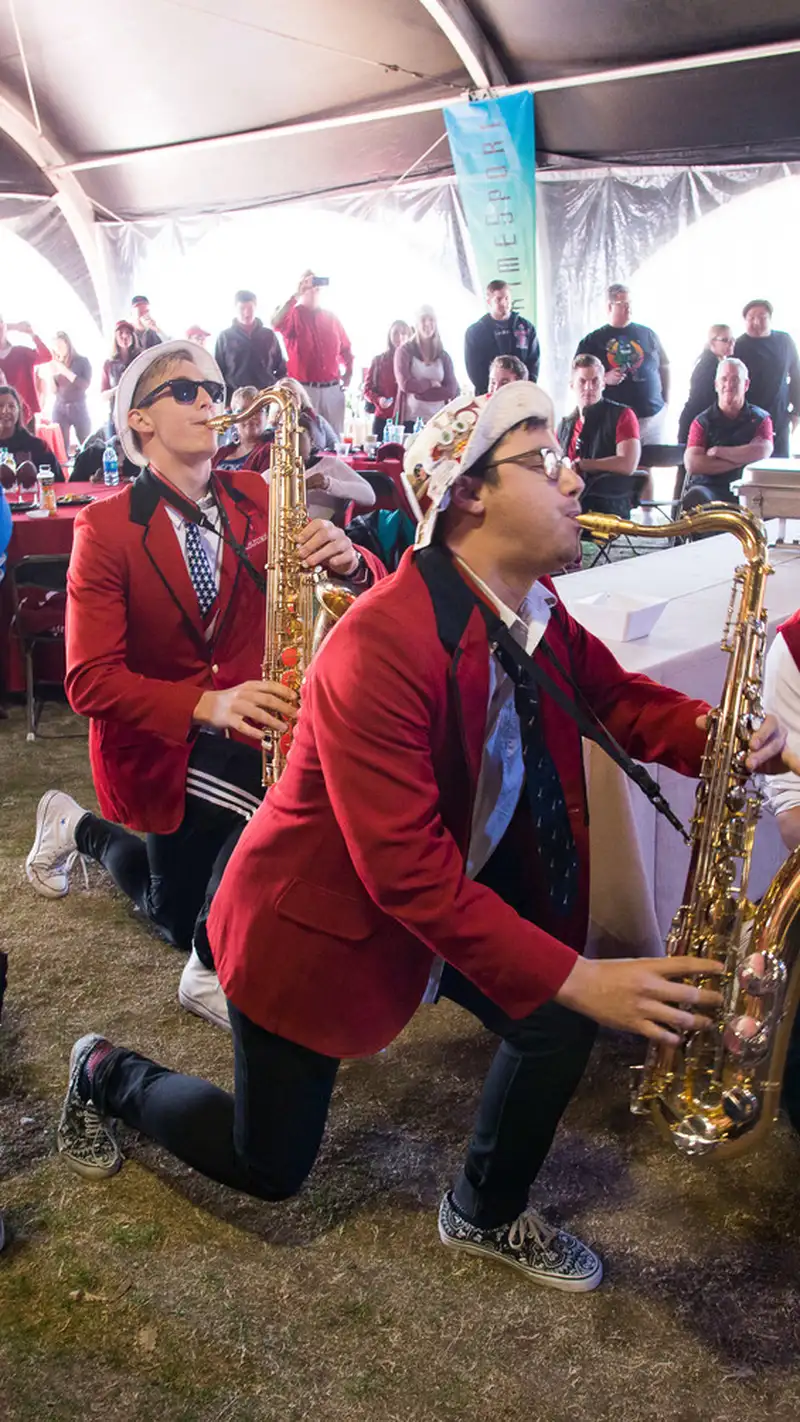 Stanford band saxophonists playing while on one knee