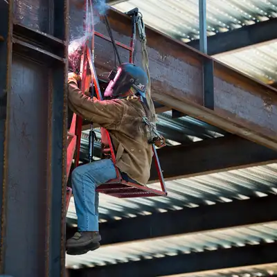 A welder works on the iron framing of the 408 Panama Mall Building.