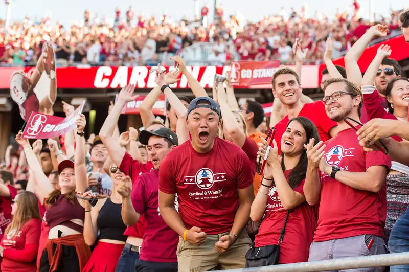 Stanford students cheering at a Cardinal football game.