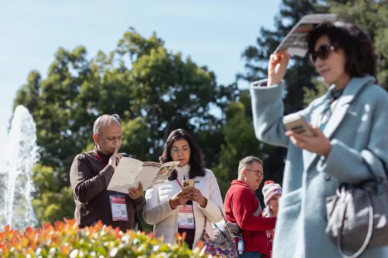 Visitors look at a brochure. A fountain burbles beside them.