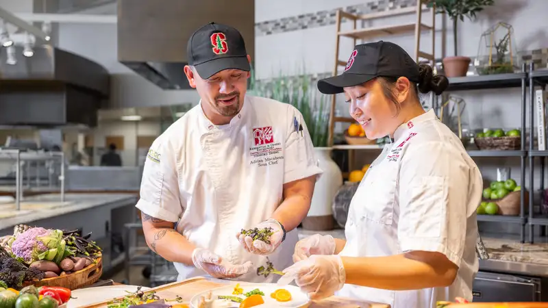 Stanford dining staff preparing fresh vegetables and herbs