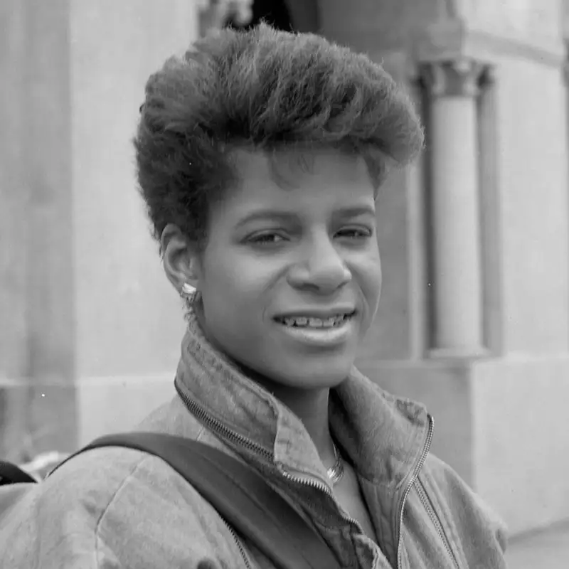 Debi Thomas smiles in a black-and-white portrait taken outdoors.
