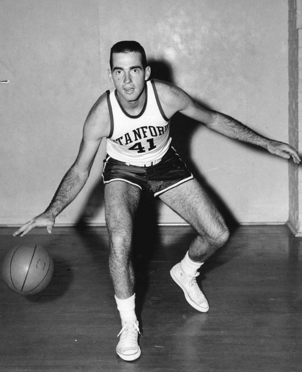 Black and white photo of young John Arrillaga with a basketball