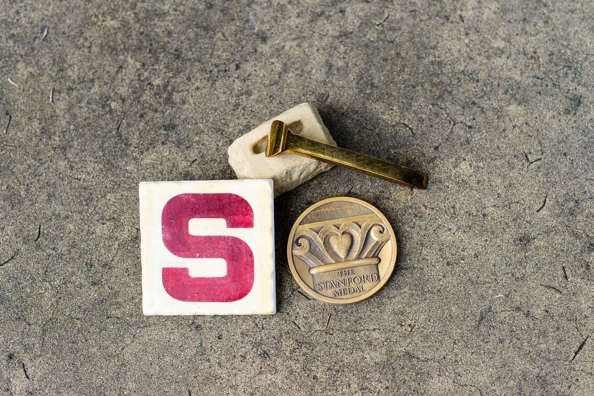 Stanford medal and golden spike on concrete background