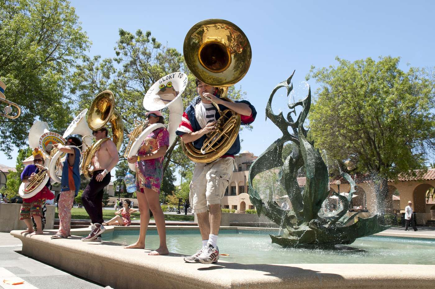 Tuba players stand on the edge of the Claw fountain