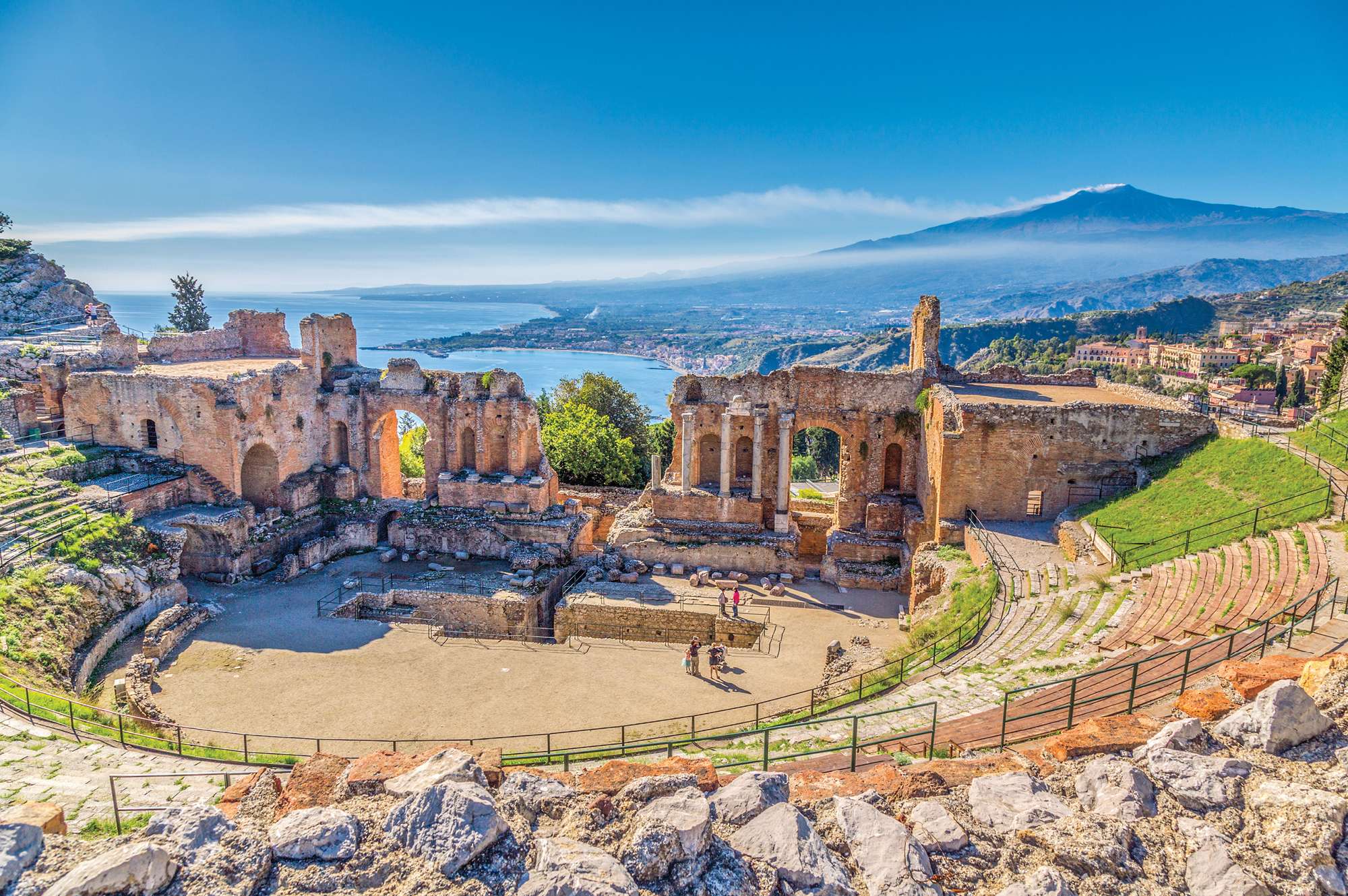 view of ancient theatre with mountain in background on sunny day