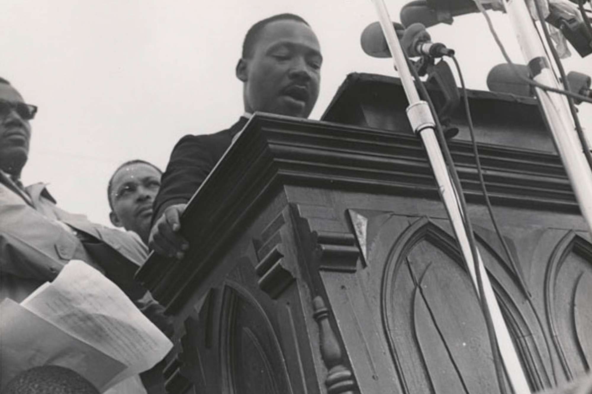 black and white image of martin luther king jr at podium speaking