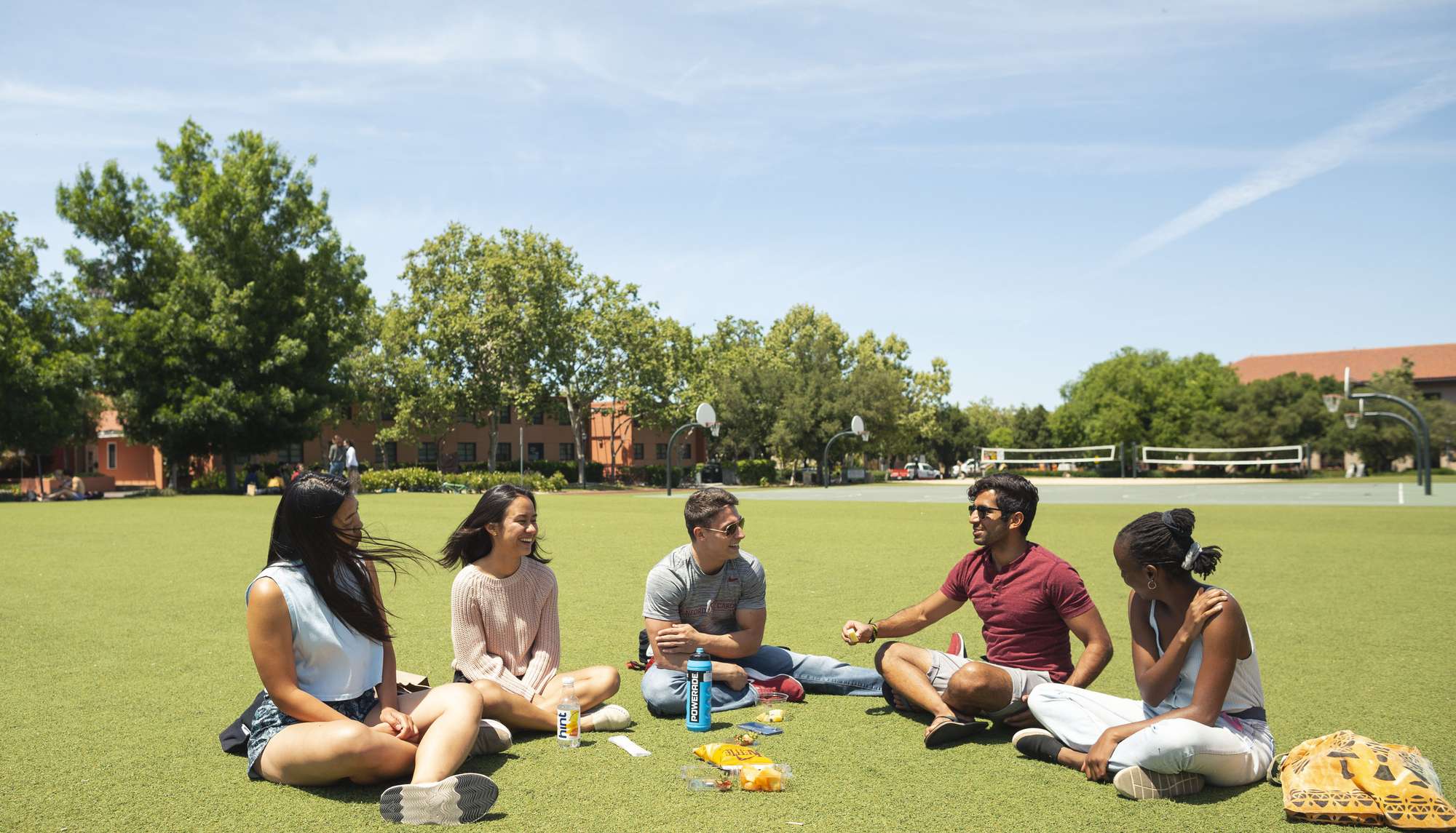 students sit together in the grass