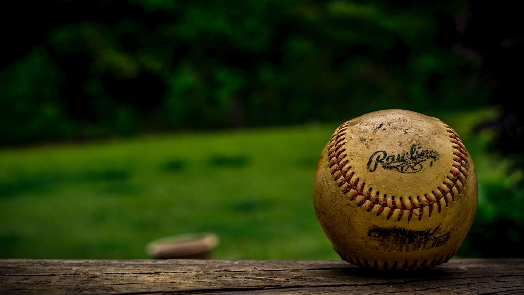 A baseball sits on some dirt