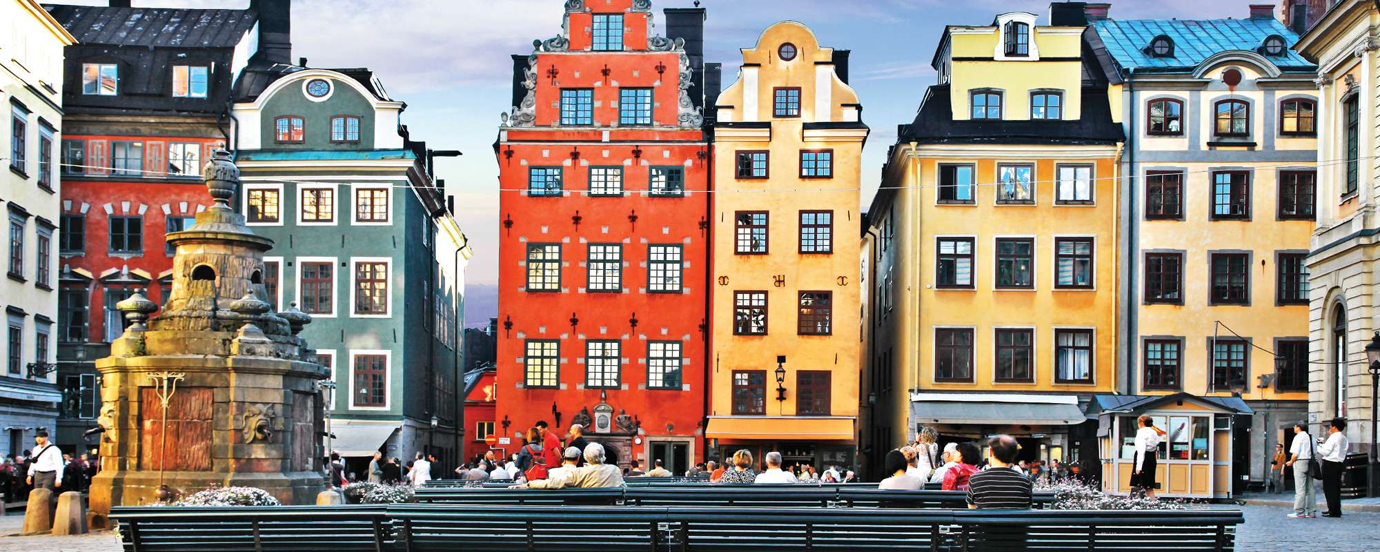 view of city buildings and park bench with visitors