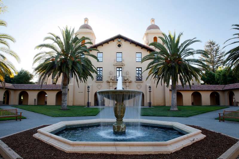 Water fountain, palm trees, and building on Stanford campus