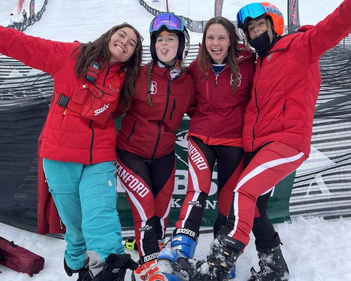 Four skiers pose on the moutain