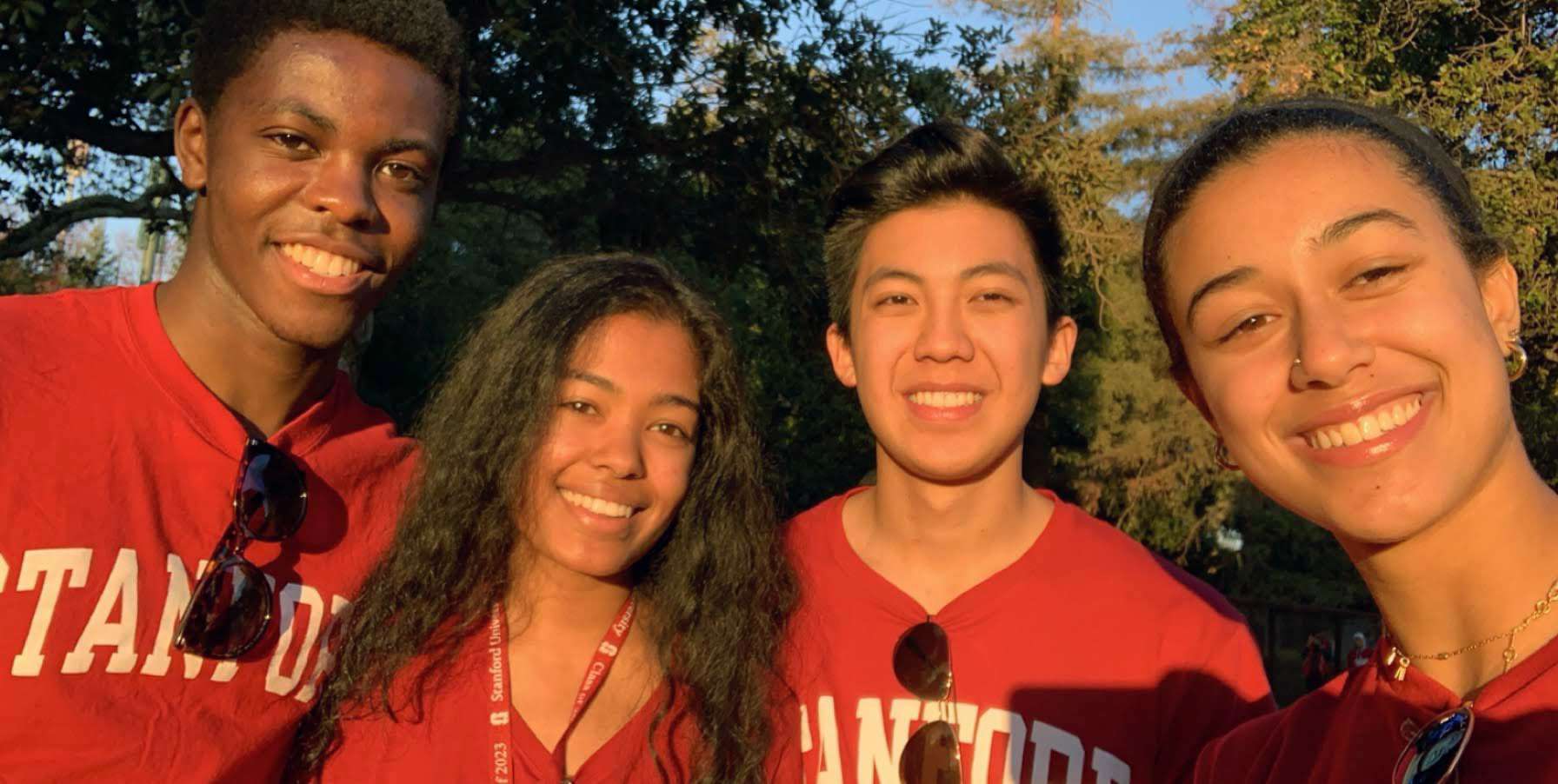 Four students in Stanford shirts smile